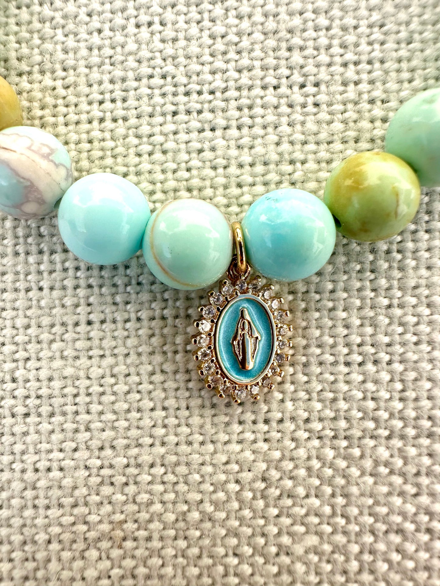 Blue swirl beach bracelet adorned with delicate blue enamel Virgin Mary Charm